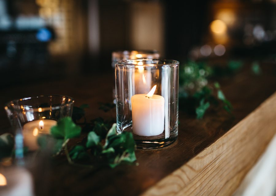 Kerzenlicht und Efeu auf einer Holztafel